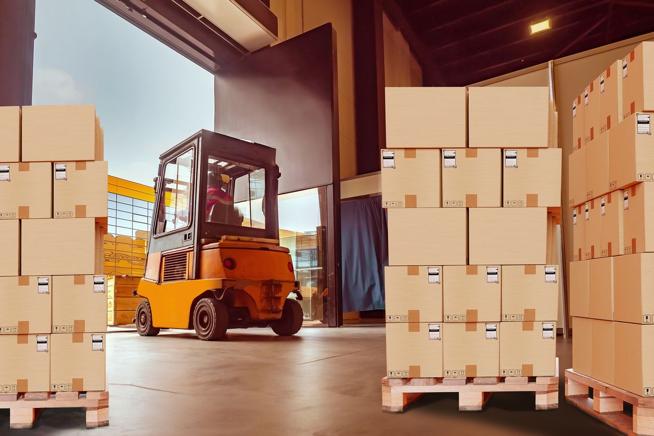 Almacén con cajas organizadas y montacargas en acción