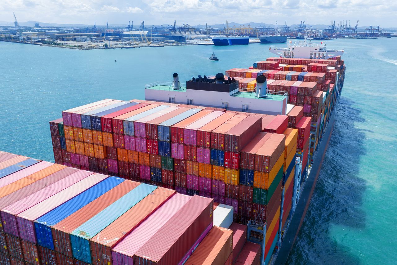 Optimización de procesos de importación industrial Vista aérea de un buque cargado con contenedores coloridos en el puerto