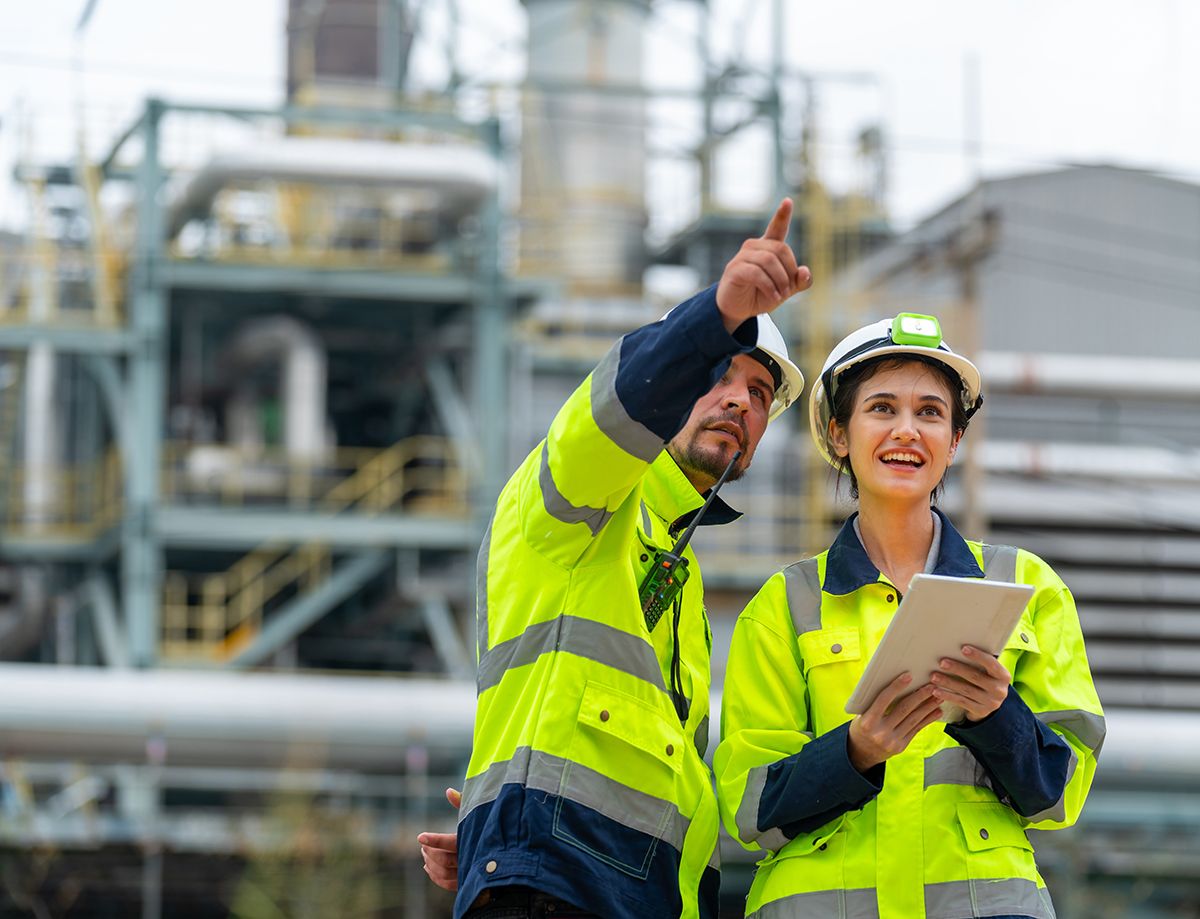 Dos trabajadores inspeccionando instalaciones en una planta petrolera.