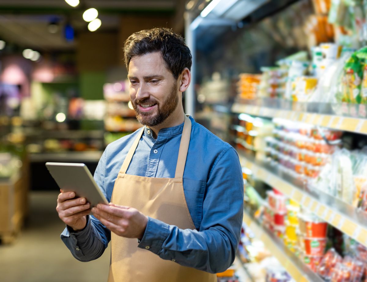 Empleado de tienda revisando inventarios con una tablet.