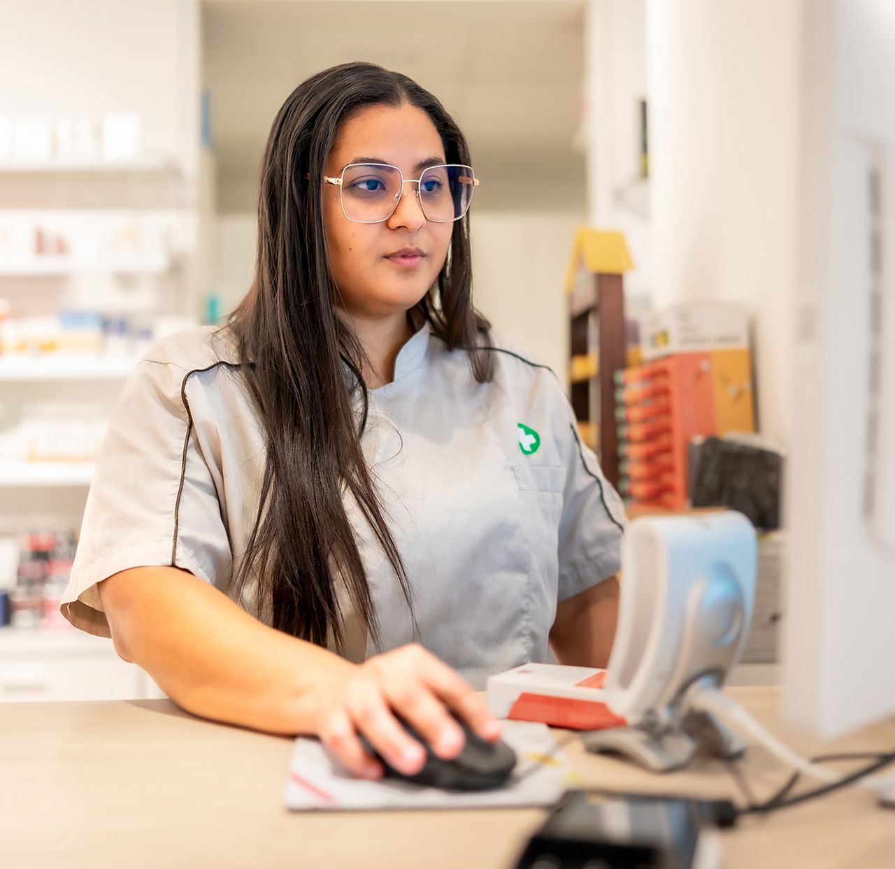 Farmacéutica operando un software desde su computadora